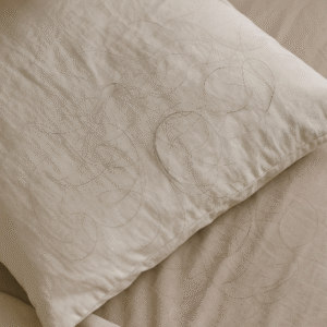 Cabellos caídos sobre una almohada blanca, imagen cotidiana que ilustra la caída capilar leve por efluvio telogénico.